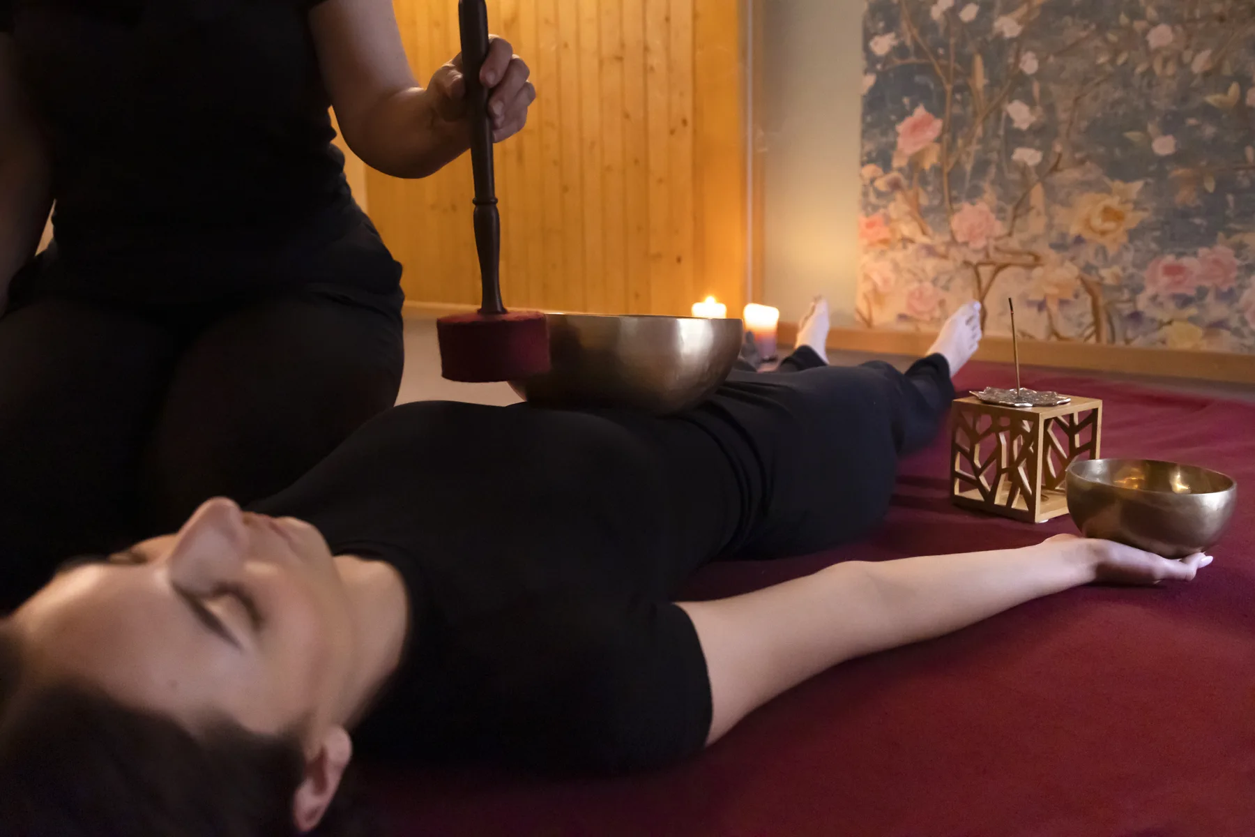 Klangschalenmassage: Schale auf dem Körper, angeschlagen mit dem Klöppel