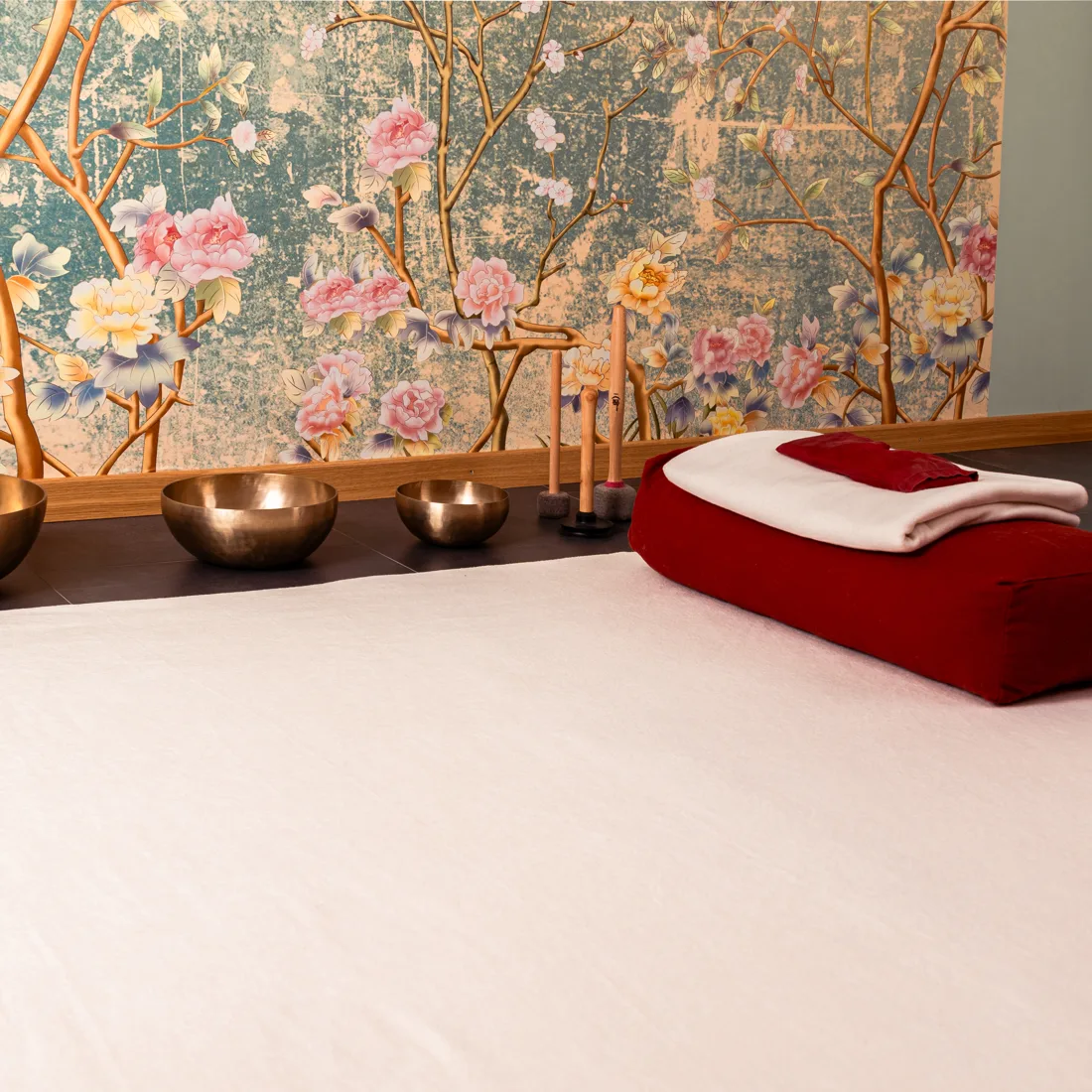 Matte mit rotem Bolster und Klangschalen im Raum 26