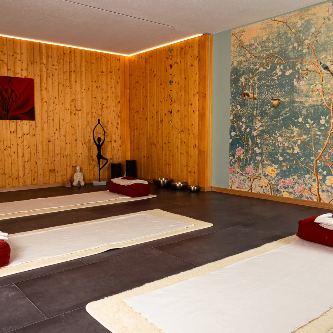 Blick in den Raum 26 mit Matten in Reihe und Holzwand